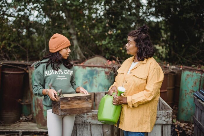ethnic-mother-talking-to-daughter-with-gardening-t Mother and Daughter Gardening