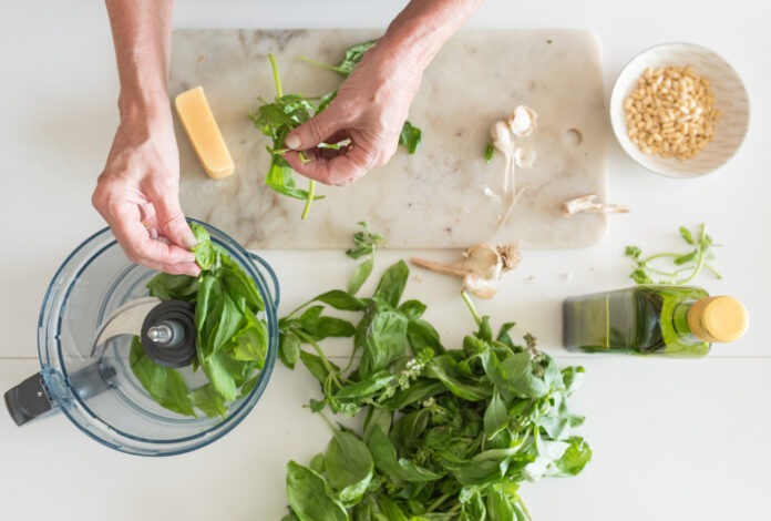 Woman's,Hand,Preparing,Basil,Leaves,To,Make,Pesto,With,Ingredients