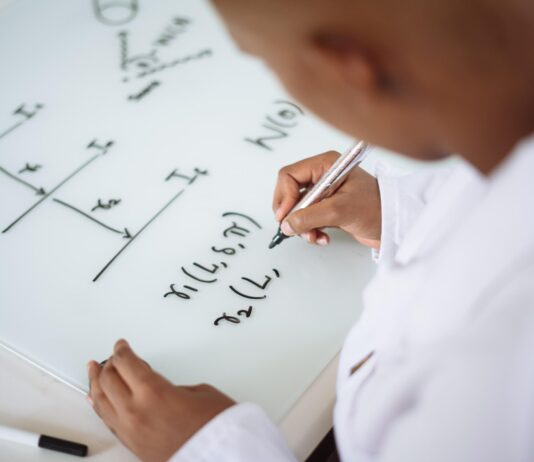 The Benefits of Taking Math Courses Online A person writing on a whiteboard Description automatically generated with medium confidence