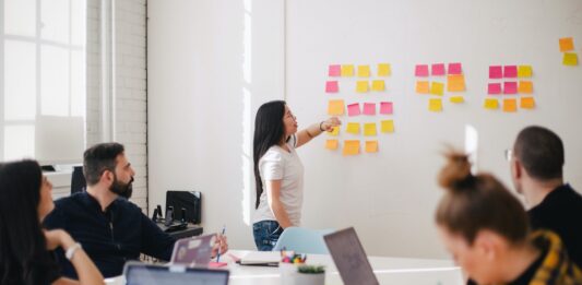 6 Customized Items For Your Business Requirements woman placing sticky notes on wall