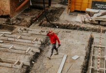 Things To Look For When Hiring A Concrete Contractor man in red jacket and black pants walking on gray concrete stairs