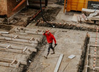 Things To Look For When Hiring A Concrete Contractor man in red jacket and black pants walking on gray concrete stairs