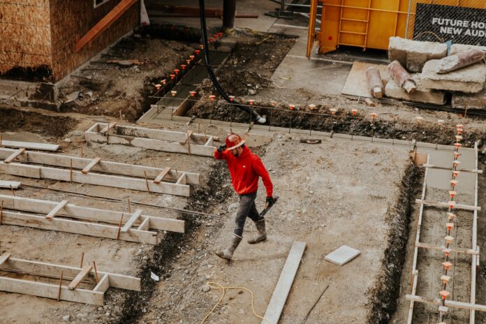Photo by Becca Tapert man in red jacket and black pants walking on gray concrete stairs