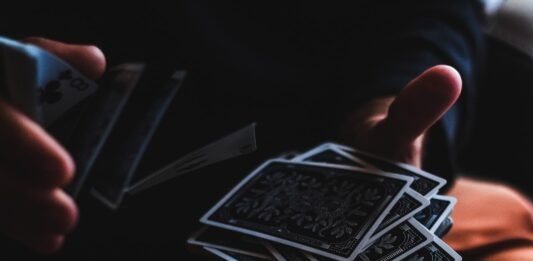 What to consider when playing online baccarat? person playing with cards