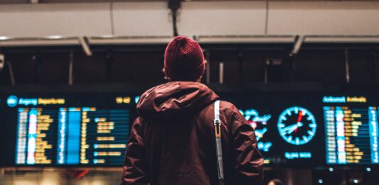 Travel Mistakes That We Bet You Surely Did Not Know! person looking up to the flight schedules