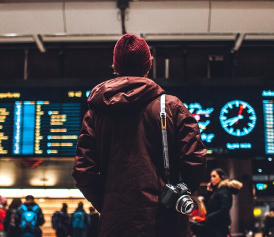 Travel Mistakes That We Bet You Surely Did Not Know! person looking up to the flight schedules