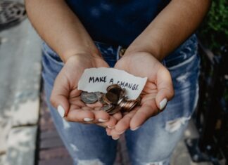 A Guide to Non-Profit Fundraising person showing both hands with make a change note and coins
