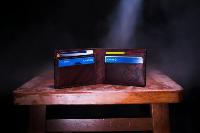 Photo by Two Paddles Axe and Leatherwork brown leather bifold wallet on table