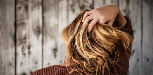 What is the best non-invasive treatment for hair loss? woman near wall