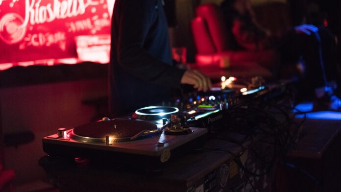 Photo by Modesta Žemgulytė person using DJ controller while standing