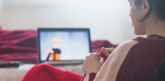 The Best Anime to Watch on Crunchyroll woman in red sweater sitting on chair