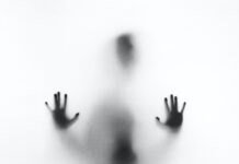 Where Can You Find The Best Reviews for Horror Movies on Hulu? person behind fog glass