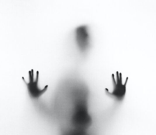 Where Can You Find The Best Reviews for Horror Movies on Hulu? person behind fog glass