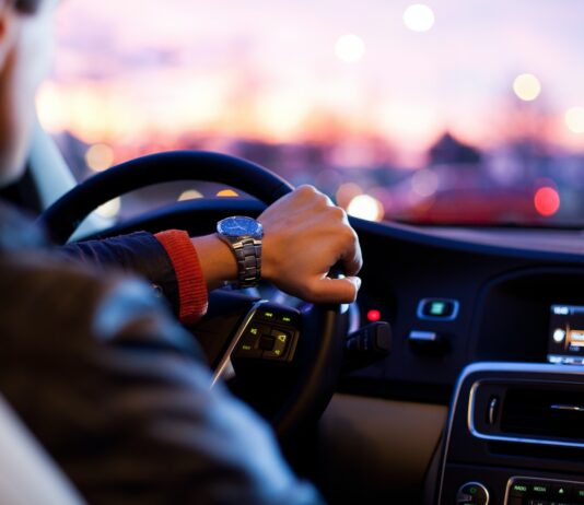 What you have to know about car insurance quotes man driving a car wearing wrist watch