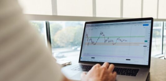 Companies That Sunk Billions in Cryptocurrency but Are Very Successful Now person using MacBook Pro on table