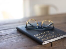 Best Books to Motivate Your Career Aspirations black and brown eyeglasses on book on brown wooden table