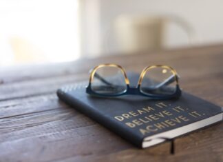 Best Books to Motivate Your Career Aspirations black and brown eyeglasses on book on brown wooden table