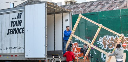 A Detailed Guide To Tipping Movers 2 boys in red shirt sitting on yellow metal bar