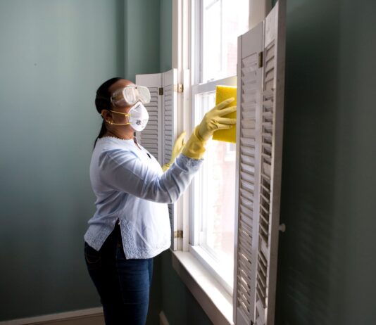 Natural Ways to Neutralize Odor in Your Home woman in white long sleeve shirt and blue denim jeans standing beside white wooden framed glass