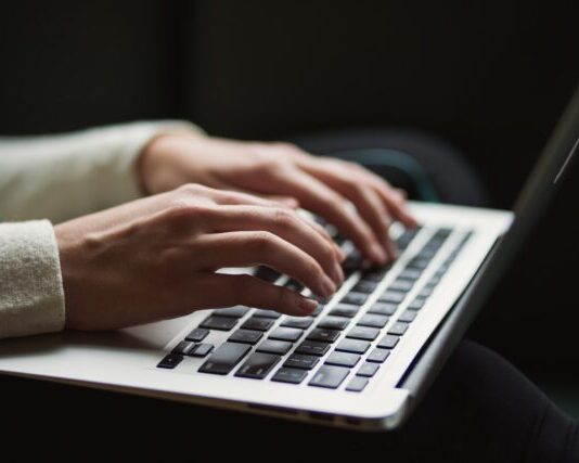 How to Become a Book Editor in 6 Easy Steps person using laptop
