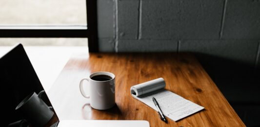 Writing an About Page for Your Site? Things to Consider MacBook Pro, white ceramic mug,and black smartphone on table