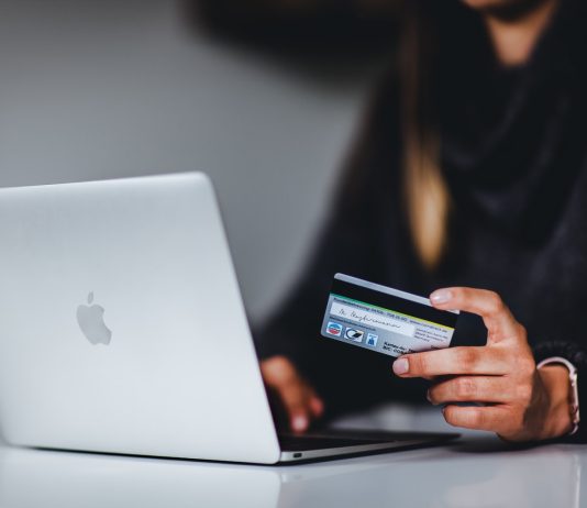 Does Consolidating Hurt Your Credit Score? woman holding black smartphone near silver macbook