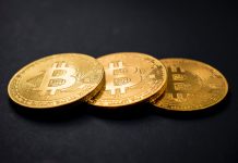 Bitcoin Prime the Automated Software three gold-colored bitcoins on black surface