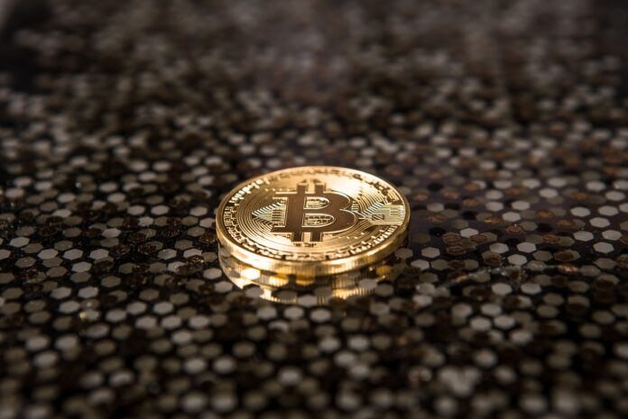 Photo by André François McKenzie gold-colored Bitcoin coin on ground
