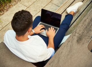 Are you ready? Questions to ask before going self-employed man wearing white sweatshirt using laptop computer sitting on sofa chair