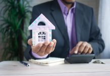 How The Fed Reserve’s Changing Interest Rates Are Affecting The US Real Estate Market man in purple suit jacket using laptop computer