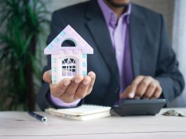 How The Fed Reserve’s Changing Interest Rates Are Affecting The US Real Estate Market man in purple suit jacket using laptop computer