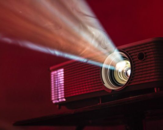 Projector and Screen Rental for Outdoor Movie Party turned on LED projector on table