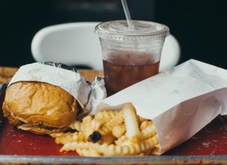 High Cholesterol: What Causes It & How Can You Treat It? burger beside fried potatoes with drinking glass