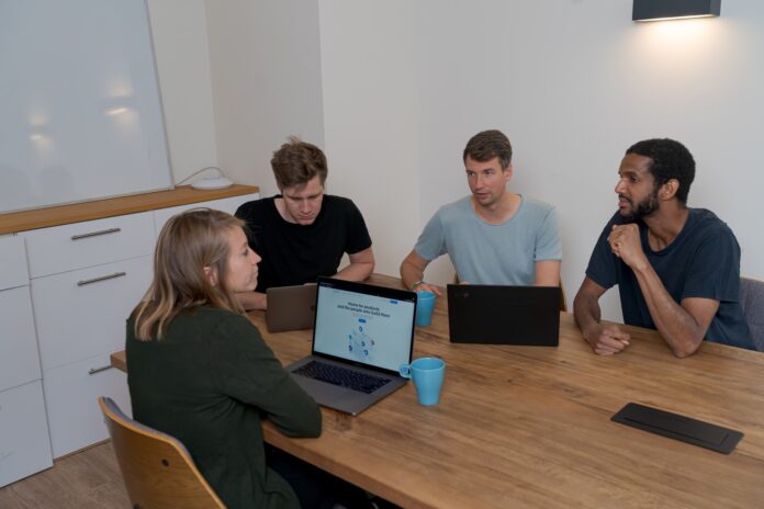Photo by airfocus group of people sitting on chair in front of brown wooden table