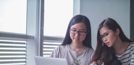 Online Casino Rules Broken Down two women discussing each other while looking on laptop