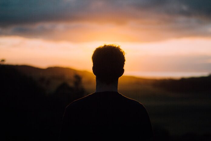 Photo by Tim Marshall silhouette of a man facing the sunset
