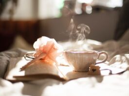 The 5 Best Teas for Relaxation teacup on book beside pink flower decor