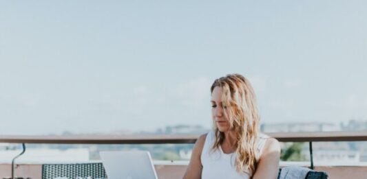 How the Digital Nomad Lifestyle Can Help You Break the 9 To 5 Routine woman sitting on chair while using MacBook