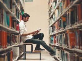 3 Ways Executive Function Skills Can Help Your College Student man sitting and leaning near bookshelf while reading book