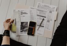 Can’t Afford to Pay Back Taxes? Here Are Your Options person holding paper near pen and calculator