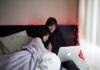 13 Most Inspiring Movies of All Time You Should Watch on Hulu couple on bed using MacBook Air beside of window with white curtain