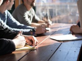 The Importance Of SEO For Pest Control Companies people sitting on chair in front of table while holding pens during daytime