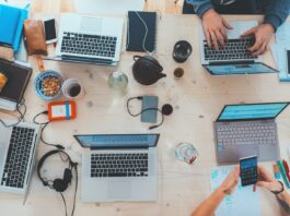 How to Use a Container Registry to Streamline Your Software Development Workflow people sitting down near table with assorted laptop computers
