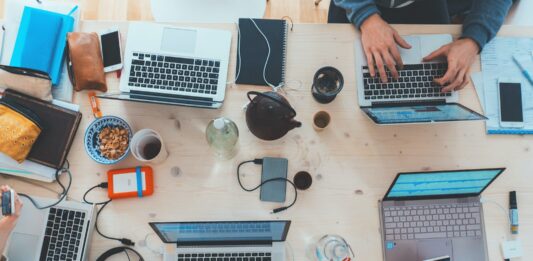 How to Use a Container Registry to Streamline Your Software Development Workflow people sitting down near table with assorted laptop computers