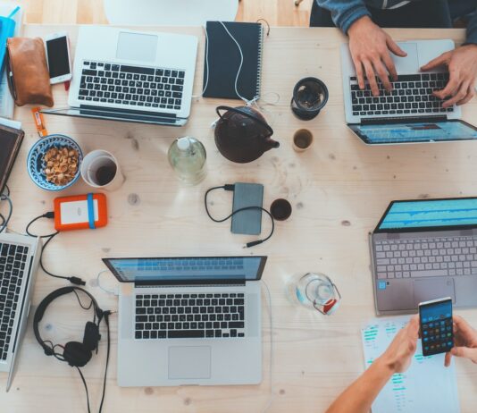 How to Use a Container Registry to Streamline Your Software Development Workflow people sitting down near table with assorted laptop computers