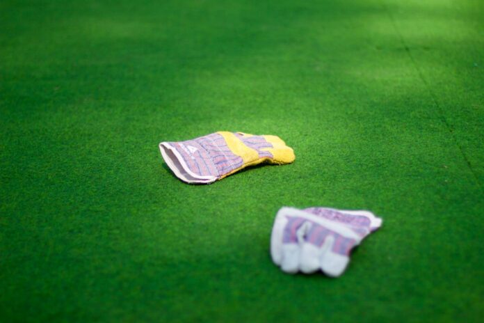 Photo by Mihály Köles pair of purple-and-white gloves on green grass lawn