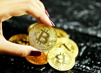 Supply Chain Relationships Are Improved by Bitcoin and Blockchain gold round coin on persons hand