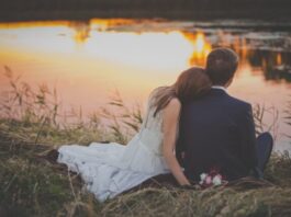 New Study Reveals the Top Traits Most Desired in a Romantic Partner sitting woman leaning on man's shoulder facing lake during golden hour