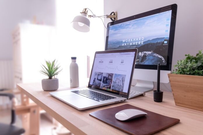 Photo by Domenico Loia MacBook Pro on table beside white iMac and Magic Mouse