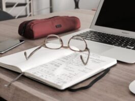 A Guide to CPA Tax Preparation eyeglasses on book beside laptop